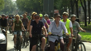 Fahrradfahrer nehmen an Fahrraddemo teil und fahren durch Bremen, einige tragen Warnwesten