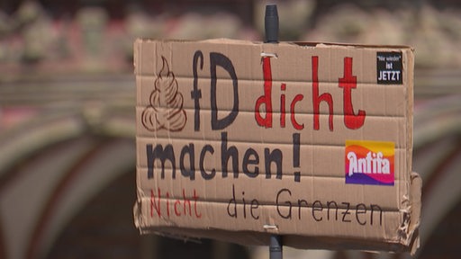 Auf einem Schild wird das Verbot der AfD Partei gefordert.