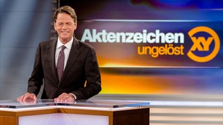 Der Moderator von "Aktenzeichen XY" guckt in die Kamera.