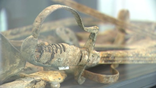 Ein antikes Schwert in einer Glasvitrine.