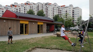 Kinder verschiedener Nationalitäten nutzen Spielplatz am Kinder- und Familienzentrum zwischen den Hochhäusern des Stadtteils Tenever am östlichen Stadtrand von Bremen.