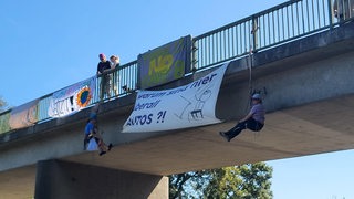 Aktivisten seilen sich an einer Brücke ab