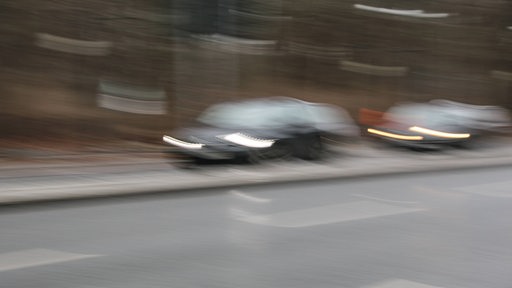 Zwei Fahrzeuge überholen sich auf einer Landstraße.