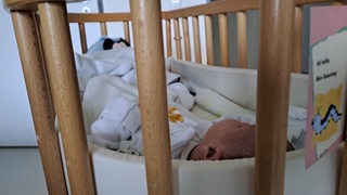 Ein wenige Tage altes Baby namens Tim in seinem Krankenhausbett