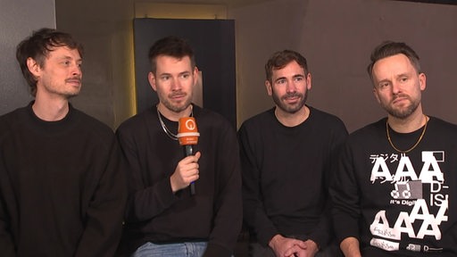 Es sind die Mitglieder der Band "Revolverheld" beim Interview zu sehen.