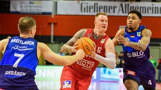 Die Basketballer Adrian Breitlauch und Jordan Samare von den Eisbären Bremerhaven versuchen, Gießens Robin Benzing zu stoppen