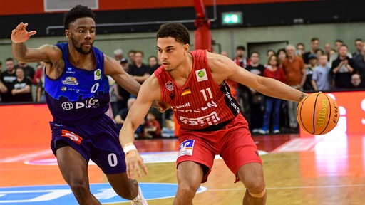 Basketballer Elijah Miller (Bremerhaven) im Duell mit Gießens Kevin McClain, der den Ball führt.