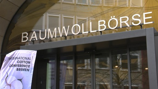 Das Eingangsportal der Baumwollboerse mit Schriftzug über der Tür.