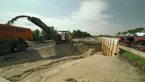 Eine Baustelle mit Bagger mitten auf der Autobahn.