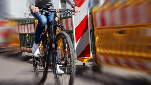 Eine Fahrradfahrerin fährt durch eine Baustelle