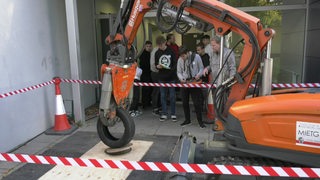 Schülerinnen und Schüler der 10. Klasse bekommen beim Berufsparcours vorgeführt, wie es auf einer Baustelle mit kleinem Krahn zugeht.