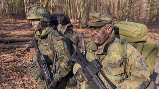 Soldaten in Tarnkleidung in einem Wald