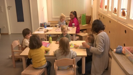 Zwei Erzieher und sechs Kinder in der Kindertagesstätte. 