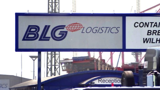 Ein Schild von BLG Logistics im Containerhafen bei trüben Wetter.