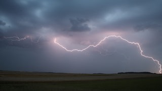 Ein Blitz zuckt am Abend über dem Himmel 