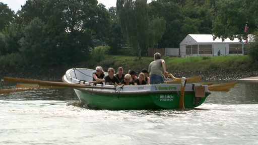 Ein grünes Ruderboot während eines Rennens auf der Weser