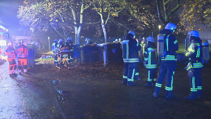 Zahlreiche Feuerwehrleute stehen an einem Einsatzort.