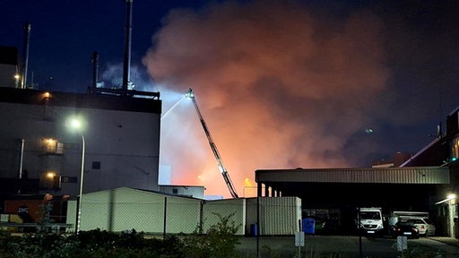 Die Feuerwehr löscht einen Brand auf einem Firmengelände im Hafenbereich von Bremen-Hemelingen. In einem Gebäude auf dem Gelände einer Firma im Hafenbereich von Bremen-Hemelingen ist am späten Freitagabend ein Brand ausgebrochen. Wie ein Feuerwehrsprecher sagte, gab es einen massiven Kräfteeinsatz. Etwa 130 Feuerwehrleute waren demnach vor Ort.