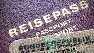 Ein Personalausweis liegt auf einem Reisepass.