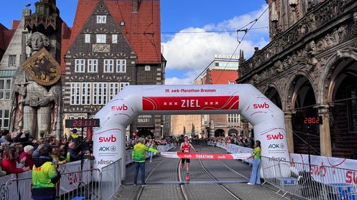 Leonard Maisch kommt als Sieger des 19. Bremen-Marathons auf dem Marktplatz vor dem Rathaus ins Ziel.