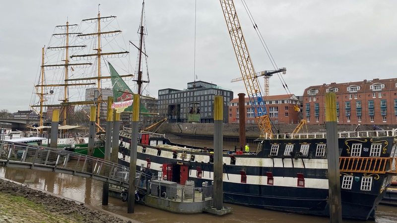 An dem an der Bremer Schlachte liegende "Pannekoekschip" wird der dritte Mast entfernt.