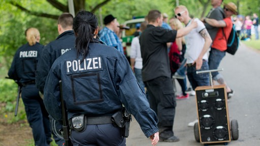 Polizisten gehen an Vatertag-Feiernden vorbei. 