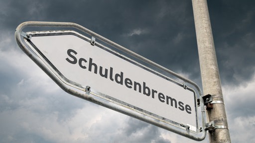 Schild mit Schuldenbremse vor dunklen Wolken