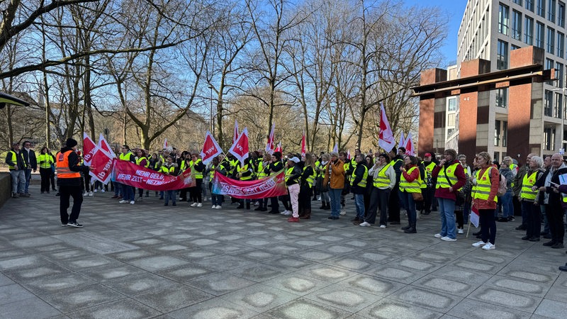 Mehrere Krankenhaus-Mitarbeiter demonstrieren vor dem Bremer Finanzamt.