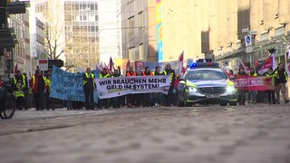 Mehrere Demonstrierende ziehen bei einem Warnstreik durch die Bremer Innenstadt