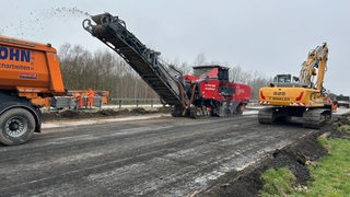 Auf einer Autobahn-Baustelle wird die Fahrbahn abgetragen.