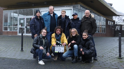 Acht Personen stehen für ein Gruppenbild zusammen.