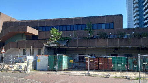 Vor dem alten Karstadt-Gebäude in Bremerhaven stehen mehrere Schutt-Container.