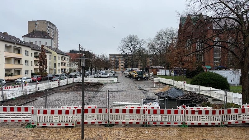 Hinter der Großen Kirche in Bremerhaven ist ein mit Bauzäunen umfasster Parkplatz zu sehen.