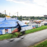 Ein Radfahrer fährt am Eröffnungsabend der Breminale am Osterdeich an der Weser in Bremen an Zelten und Buden vorbei. 