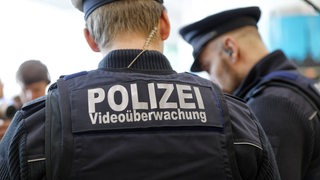 Zwei Bundespolizisten mit Videoüberwachung bei einer Kontrolle an einem Bahnhof (Symbolbild)