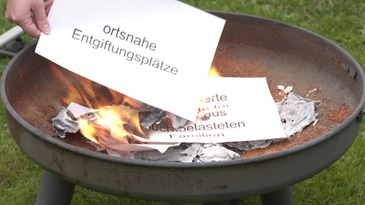 In einer Feuerschale wird Papier verbrannt.