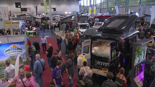 Auf der Messe "Reiselust und Caravan" sind mehrere Wohnmobile und viele Menschen zu sehen.