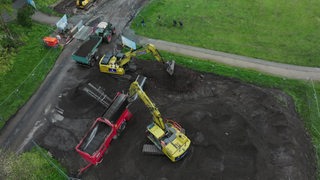 LKW und Bagger in vollem Betrieb an der Woltmershausener Weser.