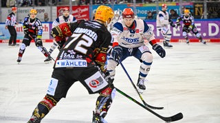 Eishockeyspieler auf der Eisbahn spielen gegeneinander.