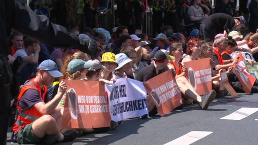 Aktivisten der letzten Generation blockieren eine Straße.