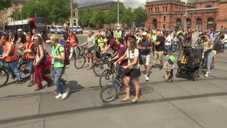 Mehrere Personen sind auf dem Bahnhofsplatz auf einer Demonstration für Verkehrswende.