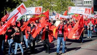 Viele in rot gekleidete Menschen ziehen bei einer Demonstration durch die Bremer Innenstadt.