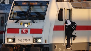 Ein Lokführer steigt in einen Triebwagen.