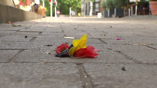 Eine Deutschland-Halskette liegt auf der Straße. 