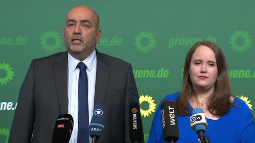 Die beiden Grünen-Bundesvorsitzenden Ricarda Lang und Omid Nouripour sprechen in mehrere Mikrofone.