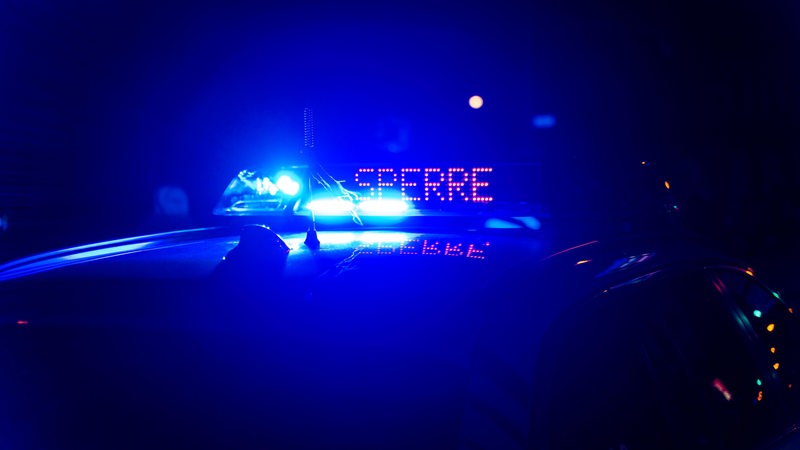 Auf einem Polizeiauto leuchtet die Aufschrift "Sperre".