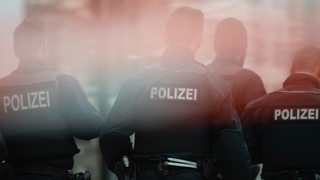 Mehrere Polizisten laufen nebeneinander. (Symbolbild)