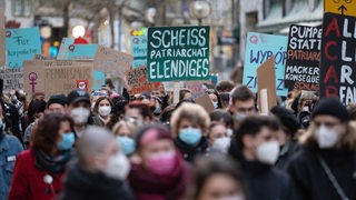 Demonstration zum Weltfrauentag mit Plakaten.