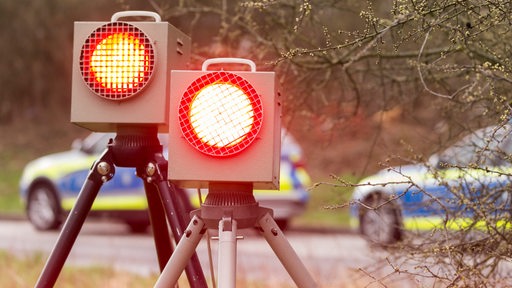 Zwei Radarkontrollanlagen stehen vor zwei Polizeiwagen