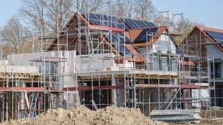 Haus mit Solaranlage auf dem Dach ist eingerüstet